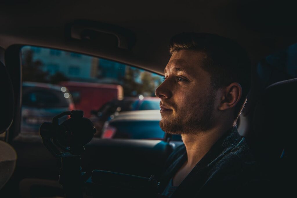 Man Sitting At the Back Holding a Camera
